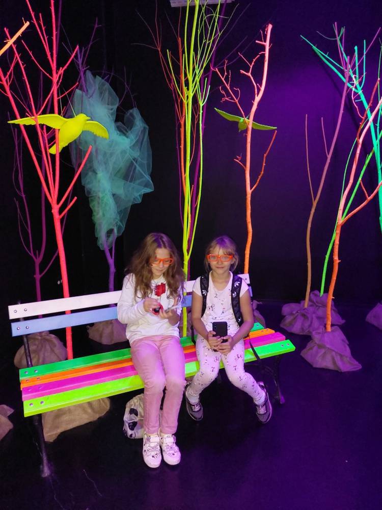Zdjęcie: Na zdjęciu: dzieci wśród kolorowych świateł, siedzące na ławce